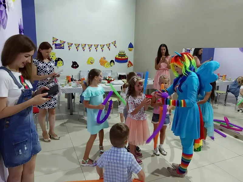 Дети с персонажем пони и длинными воздушными шарами